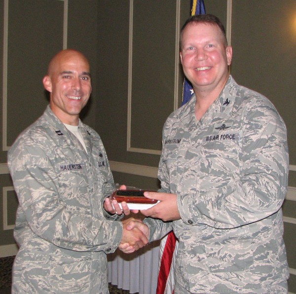 Capt. Keith Hauenstein, USAF (l), TechNet chairperson, shakes hands with Col. Bjurstrom at the June meeting. Capt. Hauenstein received the chapter's Meritorious Service Award for putting together its Heartland TechNet for 2013.